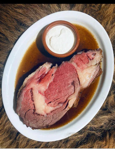 Bison prime rib roast on plate with jus