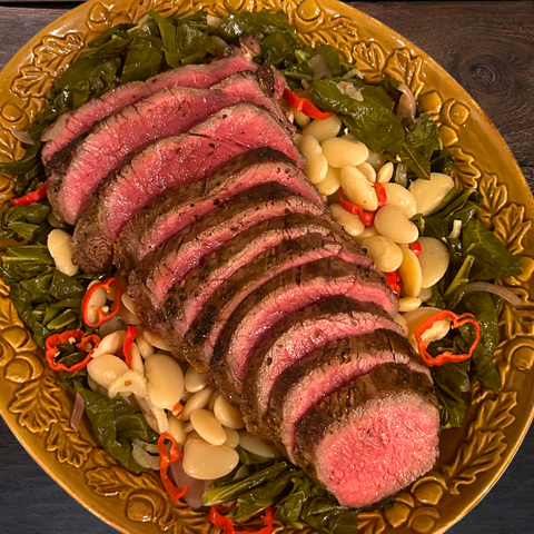 Bison Tri Tip roast on plate with white beans